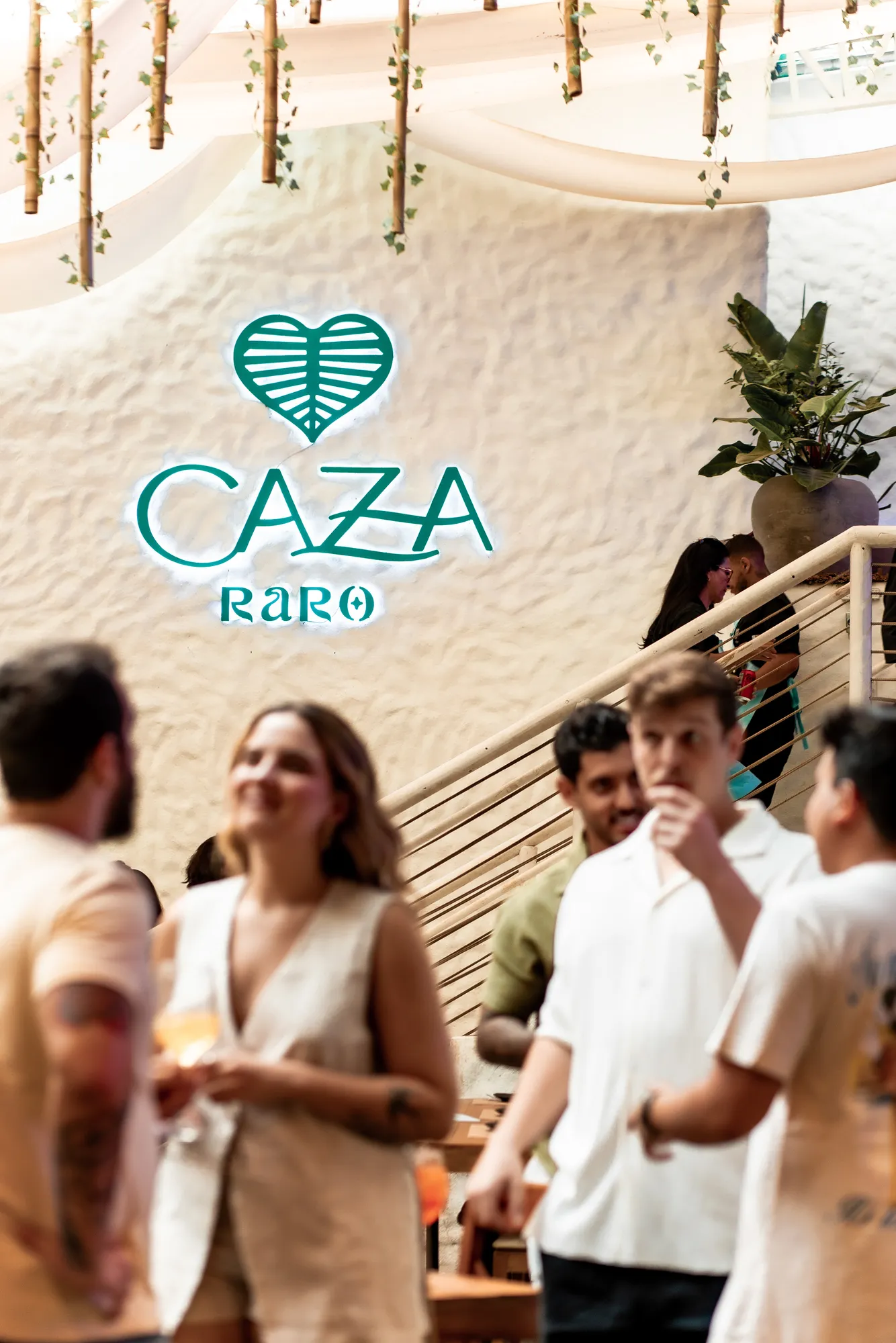 Amigos conversando diante do painel CAZA RARO · 29 de março de 2025