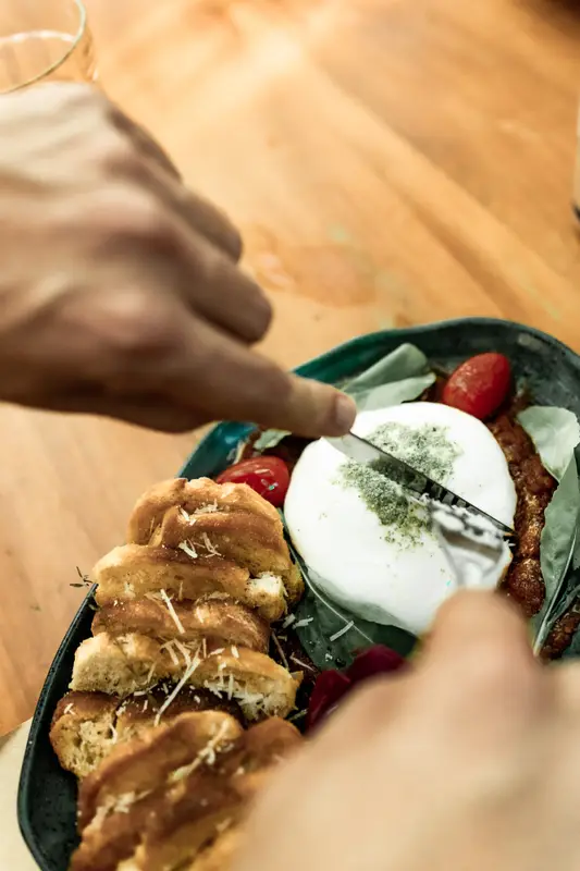 Burrata e pães servidos na Caza Raro, vistos de cima