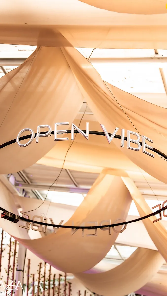Tecidos claros no teto da Caza Raro e o letreiro OPEN VIBE