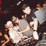 DJs na cabine com o público ao redor