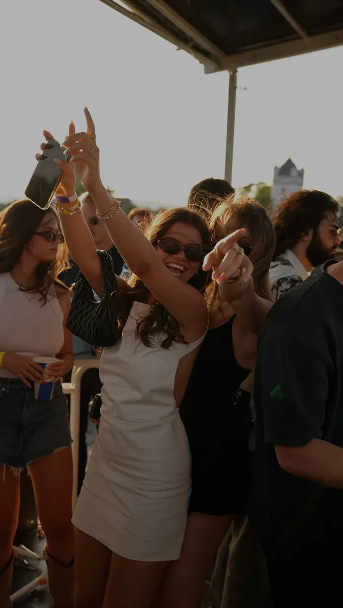 Gente dançando sob o toldo do beach club no fim de tarde